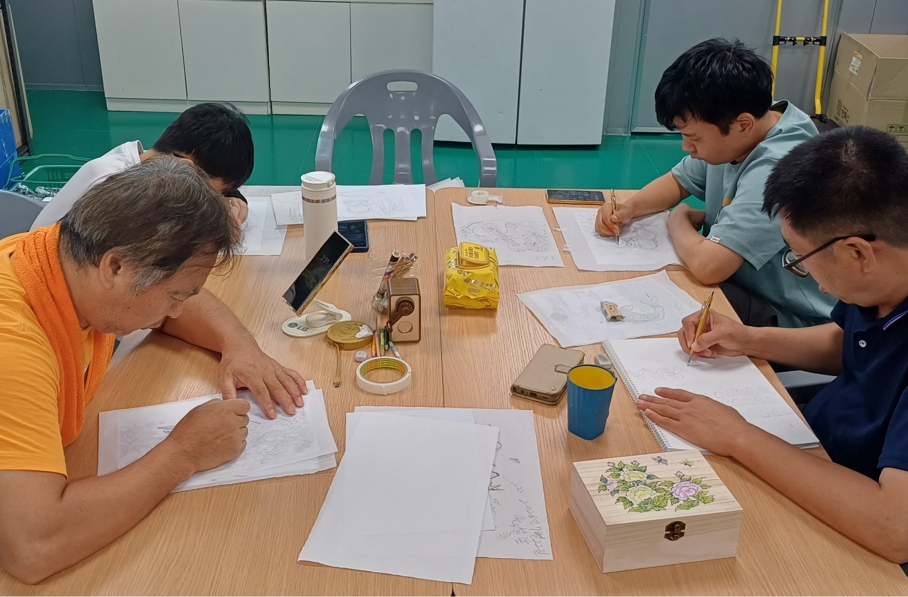 태장 근로자들이 함께 민화 밑그림 작업을 하는 모습